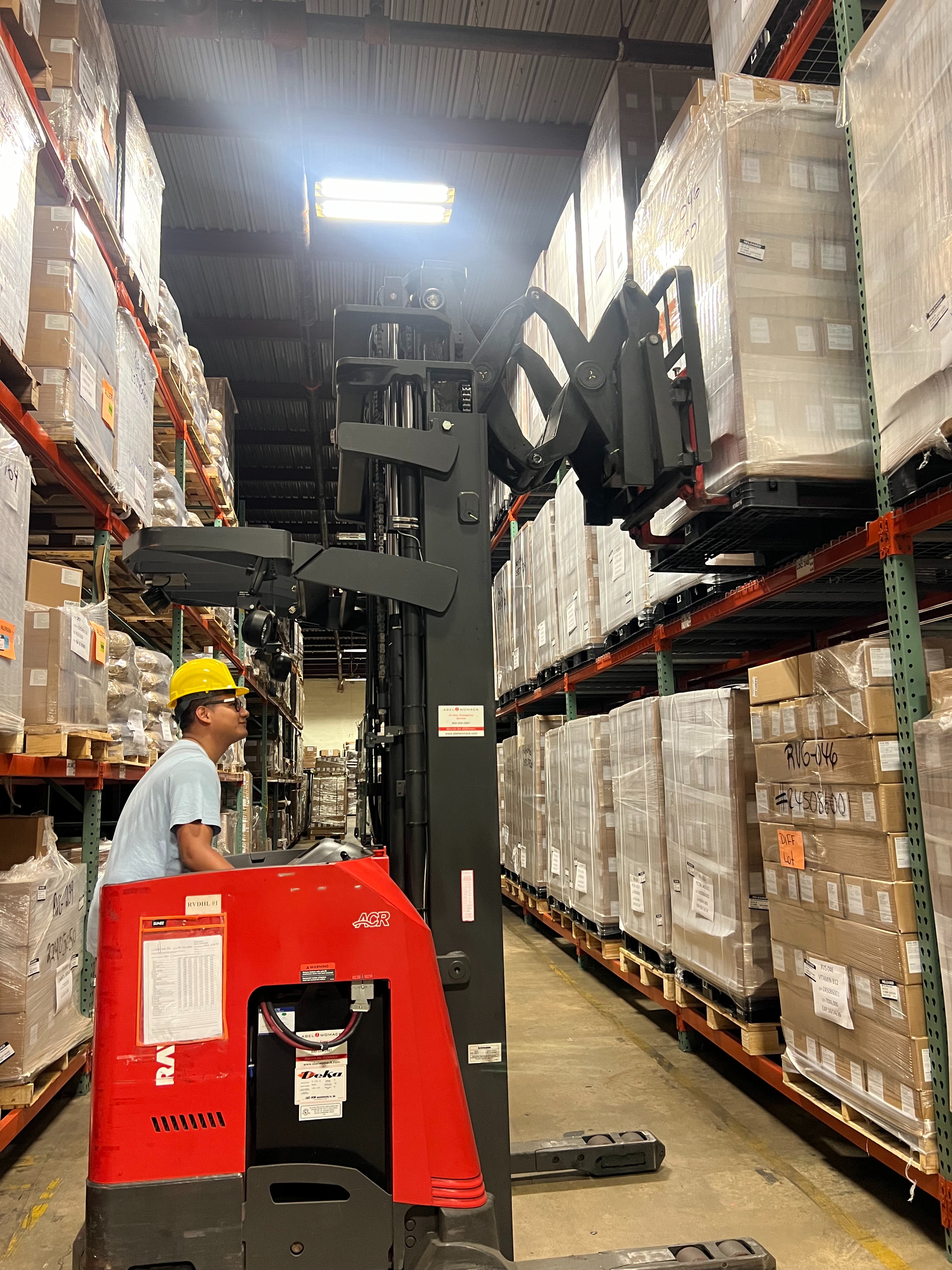 RV Pharma warehouse operator moving a palletized supplement load with a reach truck